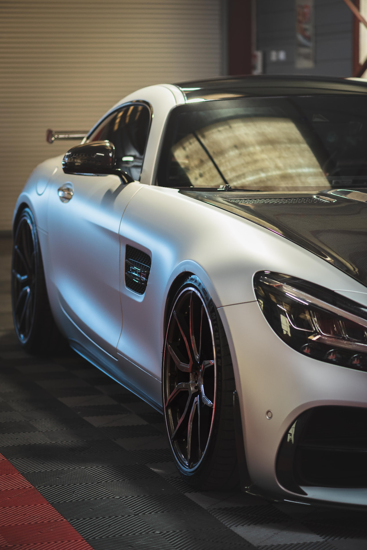 Mercedes-AMG GT blanche mate photographiée de trois-quarts avant dans l'atelier