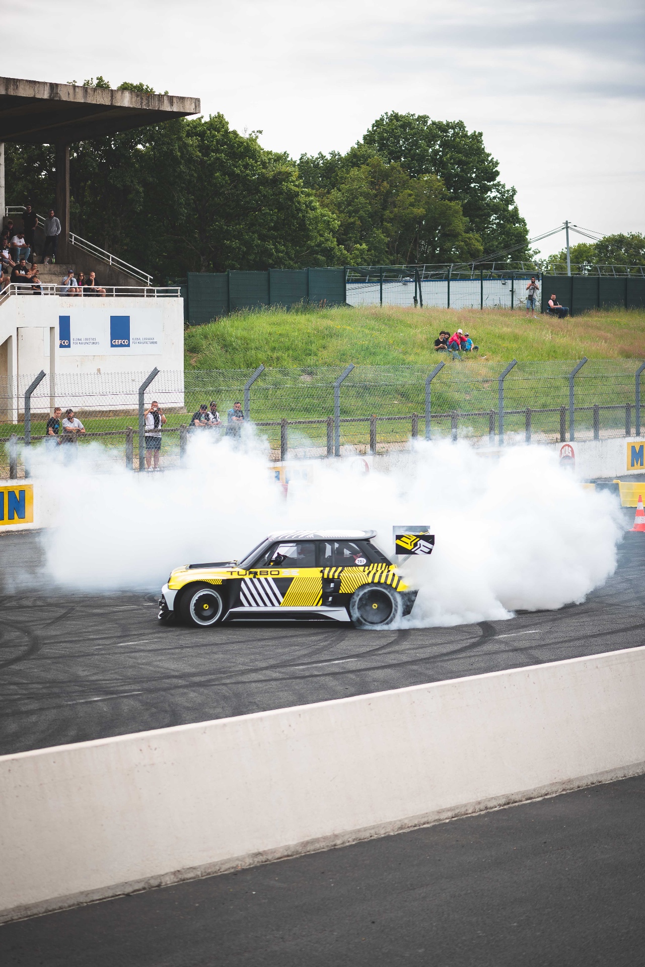 Renault 5 Turbo 3E en burnout sur la piste de Montlhéry, nuage de fumée