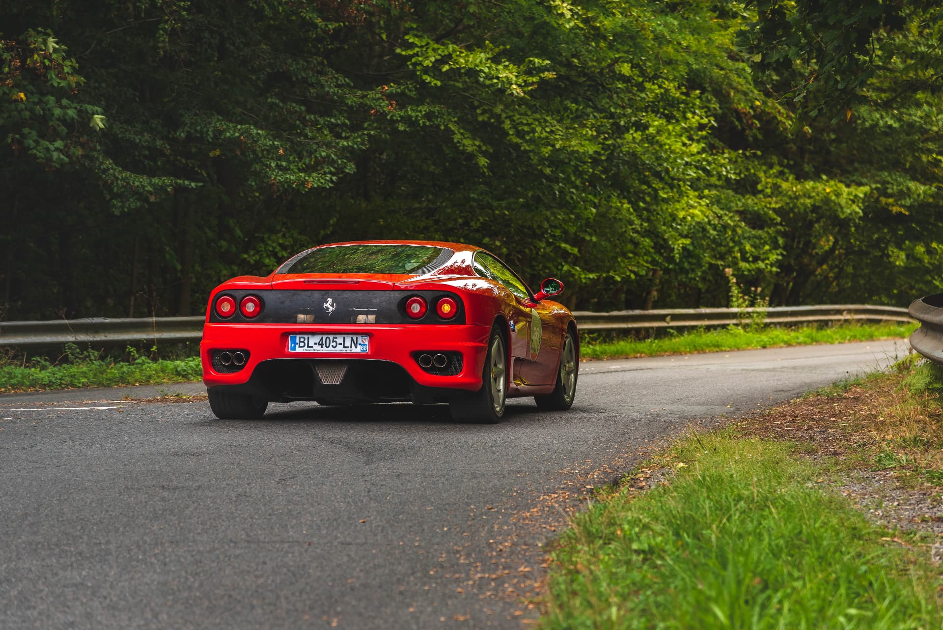 Ferrari rouge dans un virage boisé