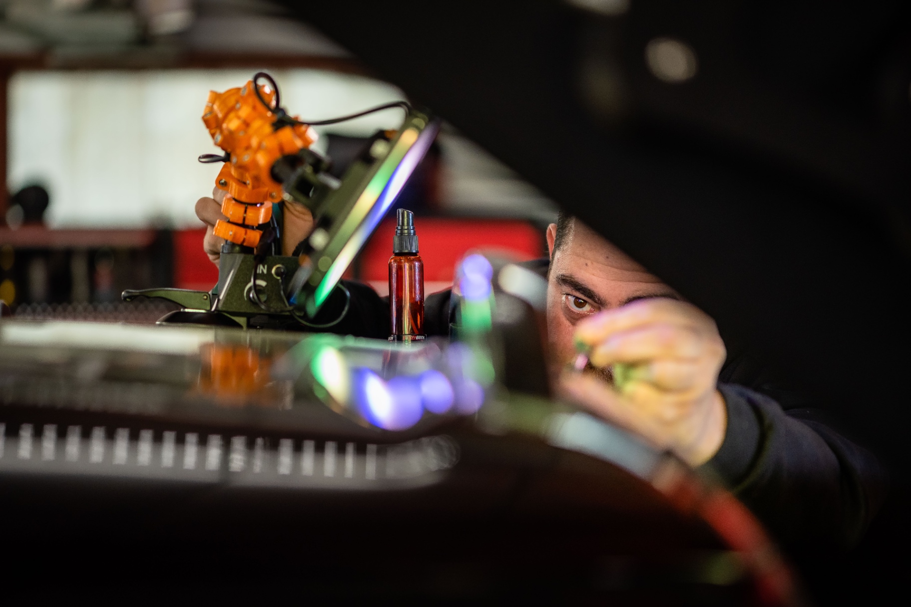 La lampe orange, le spray et le regard d'Axel qui traverse la lumière