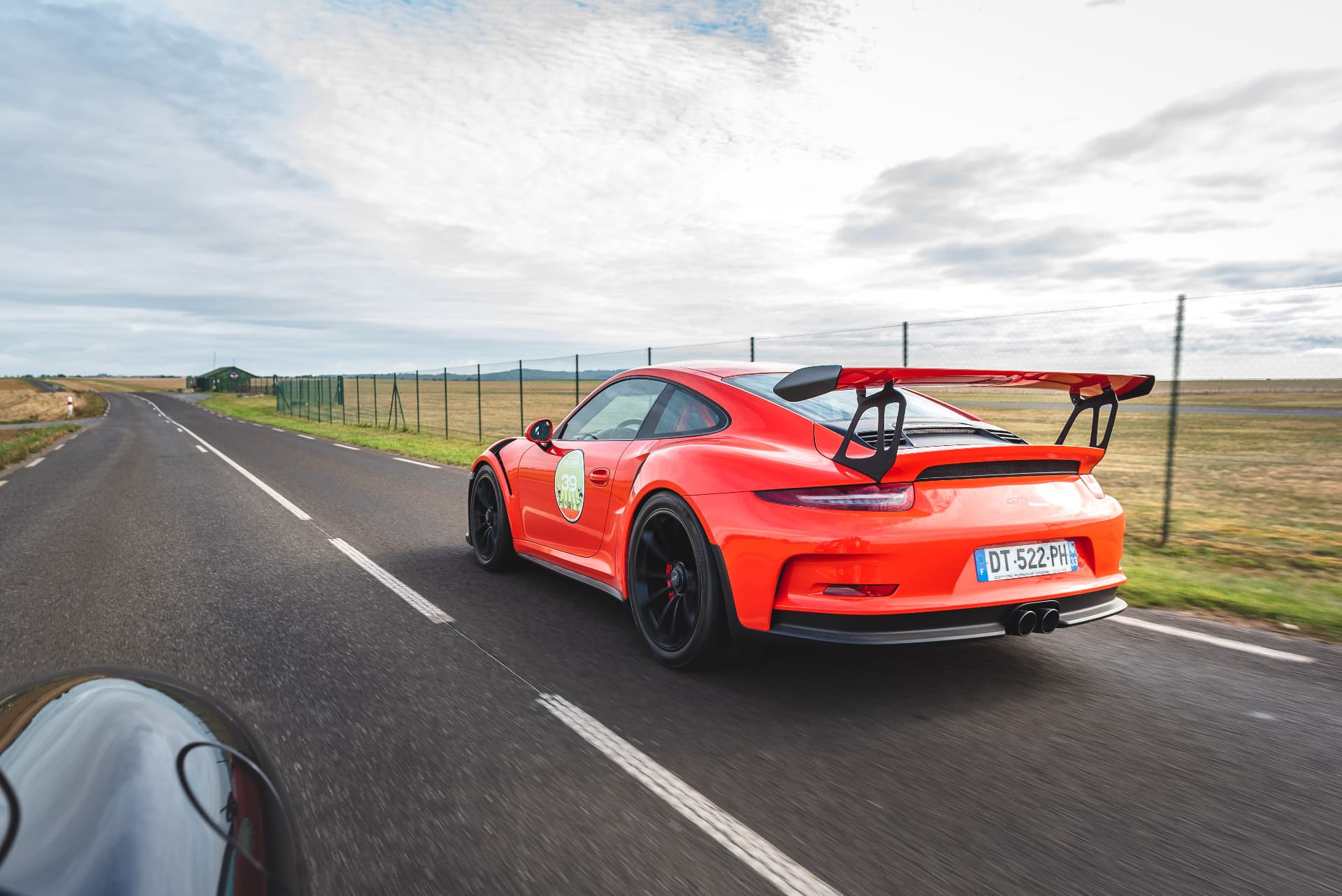 Porsche rouge traversant la campagne