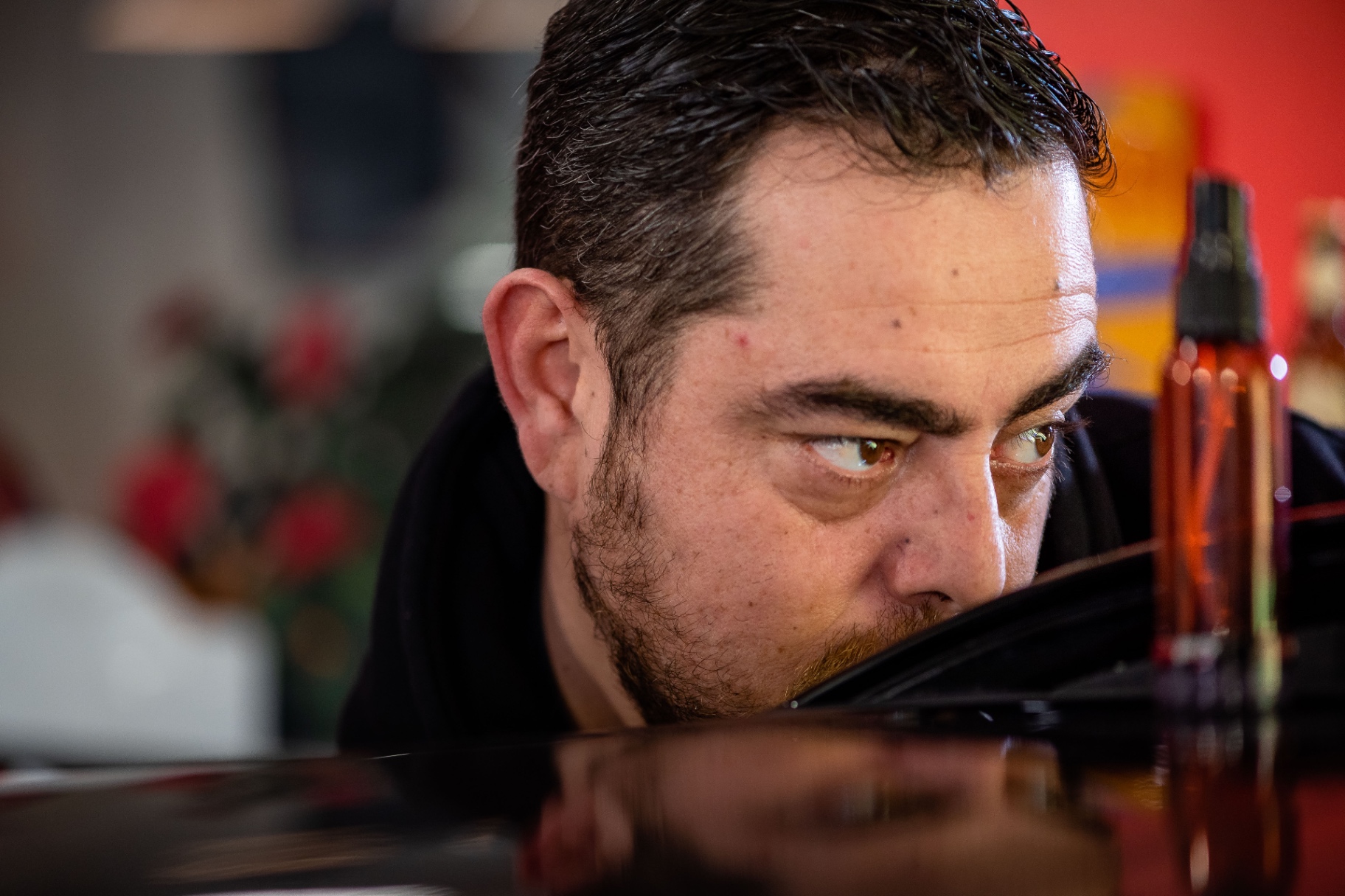Regard d'Axel à hauteur de carrosserie, cherchant la déformation dans le reflet