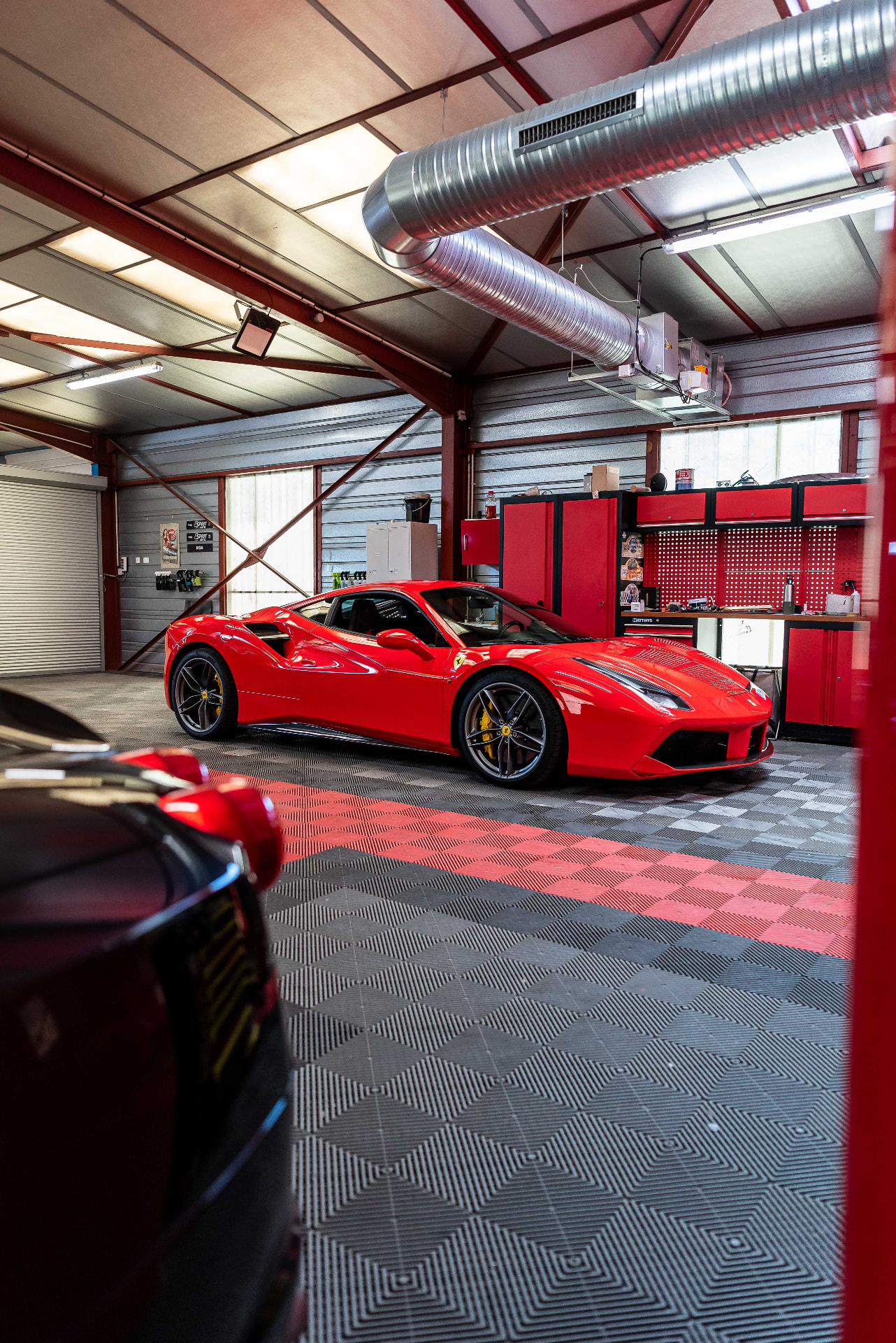 Ferrari rouge stationnée dans l'atelier Esprit Auto