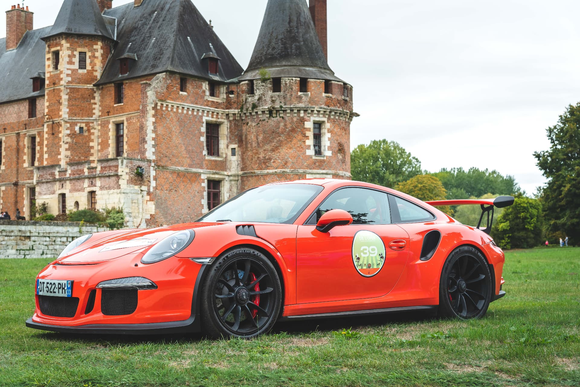 Porsche rouge devant un château
