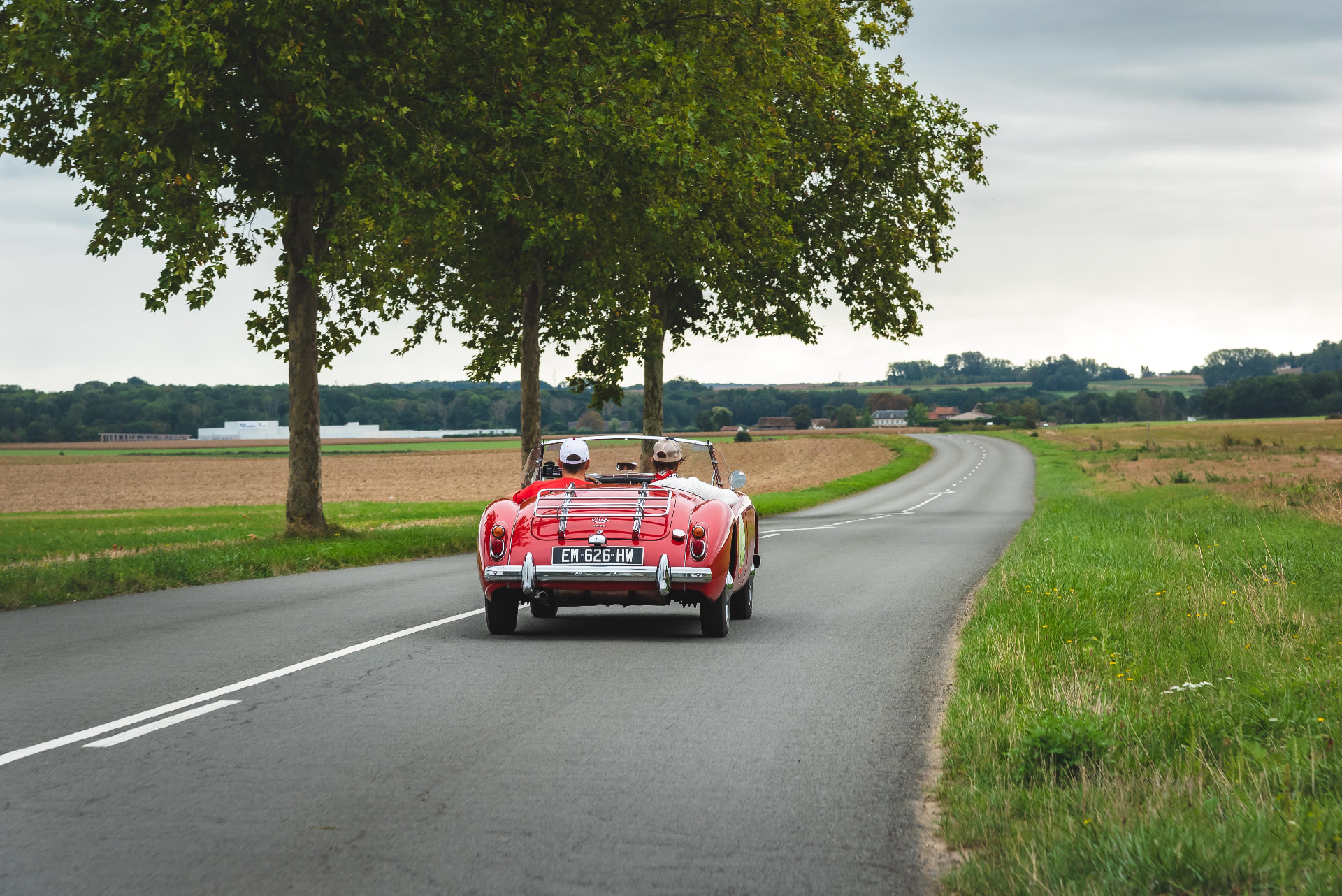 Roadster ancien rouge sur une route de campagne