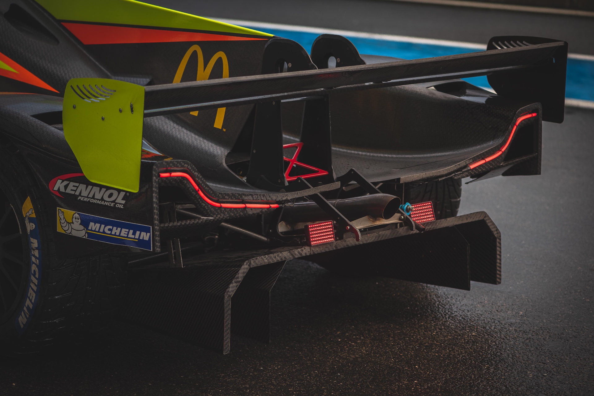 Détail arrière — aileron jaune, diffuseur carbone et pneu Michelin