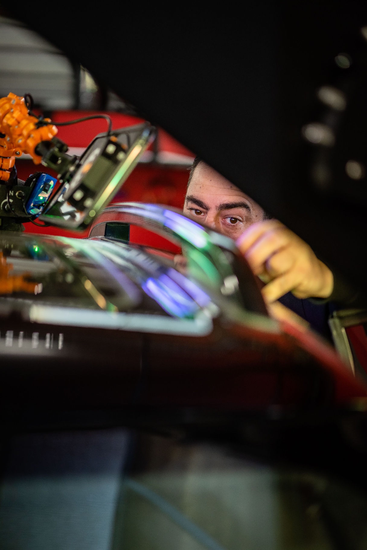 Axel observe la surface à travers l'ouverture du capot, éclairé par la lampe LED
