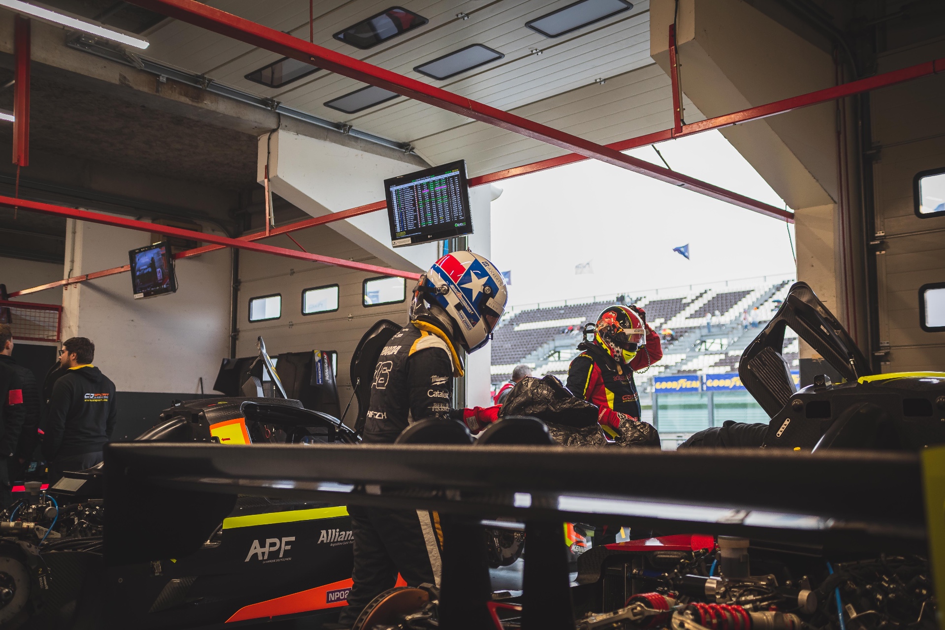Pilotes et mécaniciens dans le garage Magny-Cours avant la session