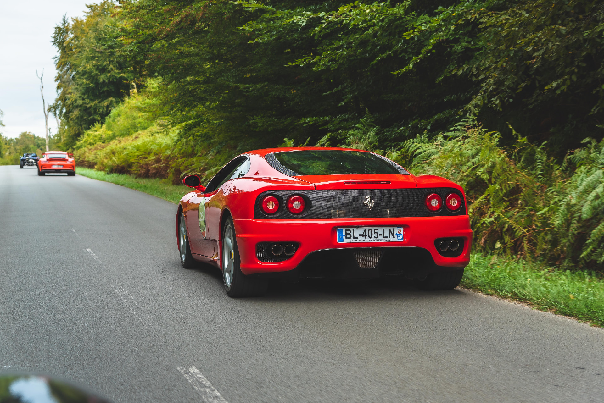 Reportage Rallye de l'Open — Club d'Aumale, Ferrari rouge sur une route forestière
