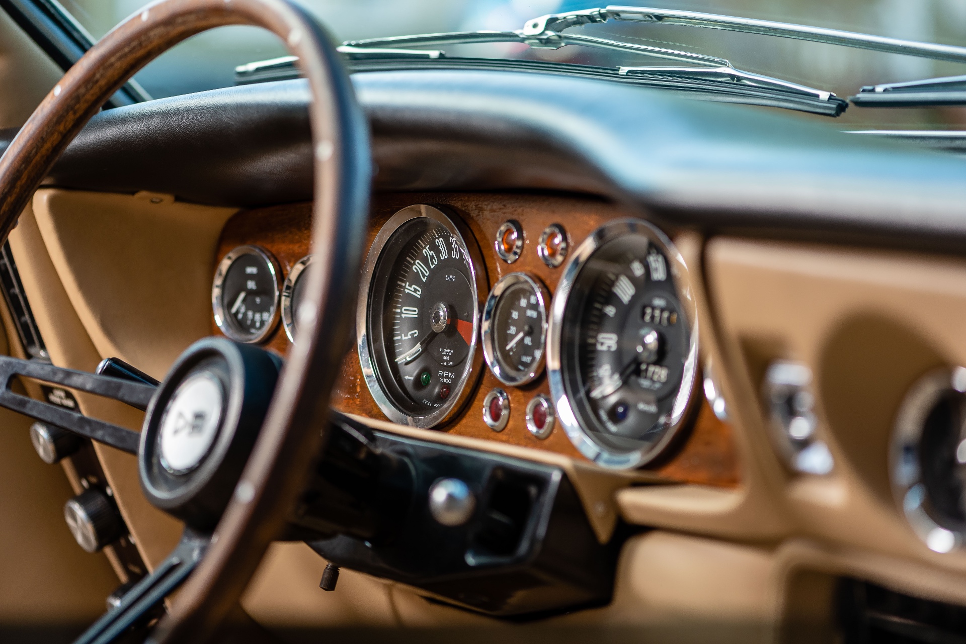 Tableau de bord Aston Martin DBS, compteurs chromés sur boiserie cintrée