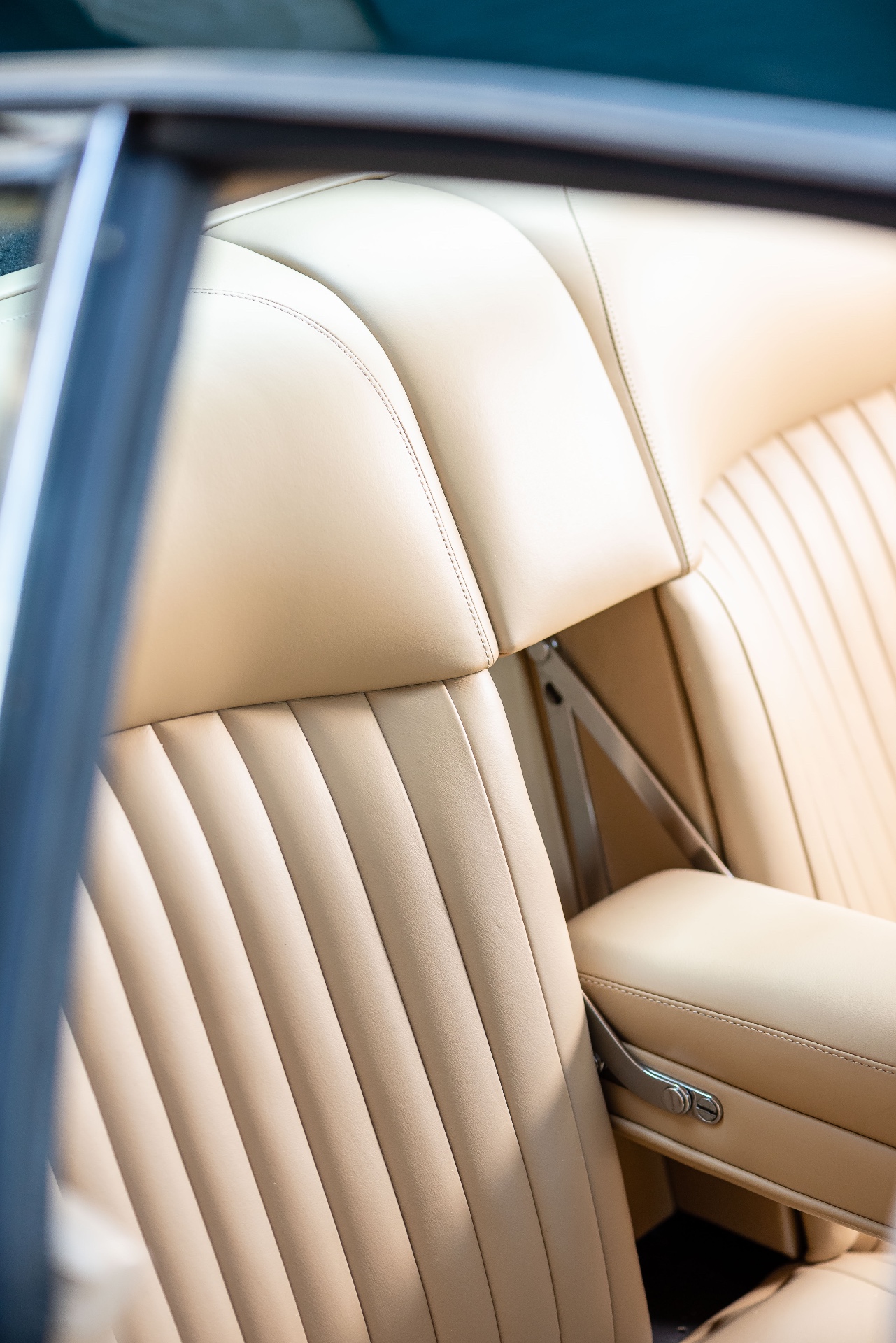 Détail vertical du siège cuir crème de l'Aston Martin DBS, plis sellier