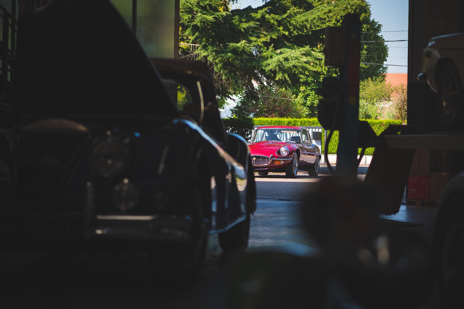 Reportage Cecil Cars — coulisses de l'atelier, Jaguar Type E rouge au loin