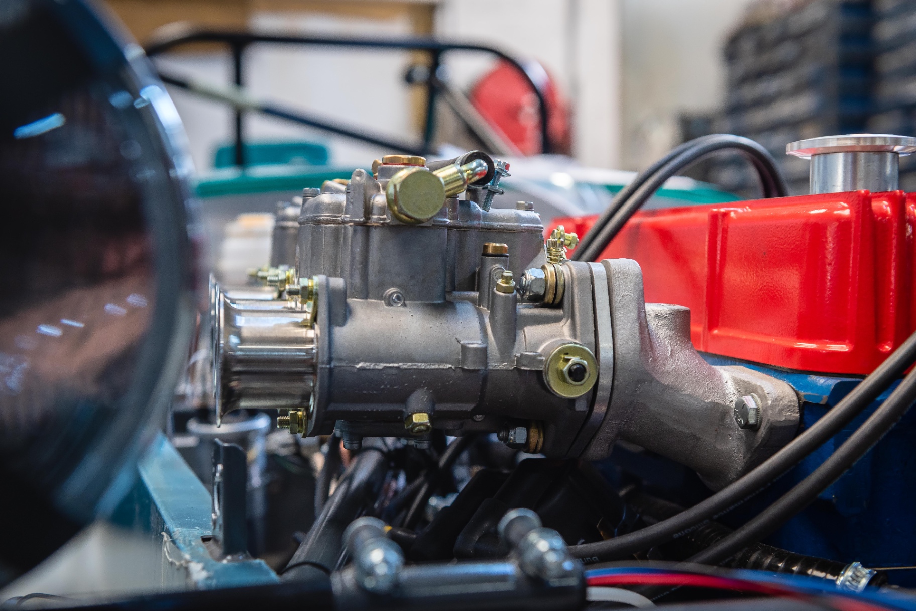Macro mécanique — carburateurs sur moteur restauré, cache rouge Cecil Cars