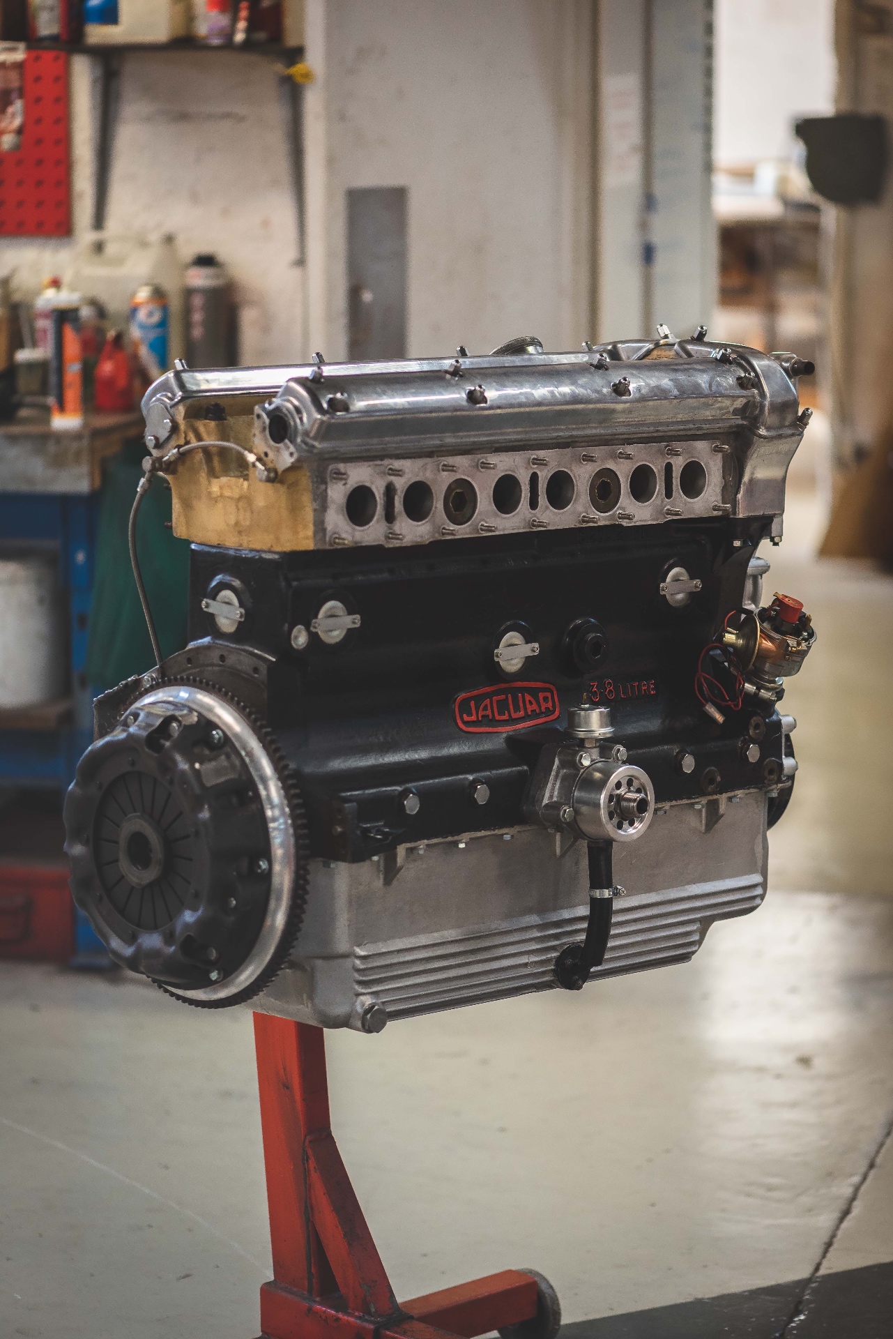 Moteur Jaguar 3.8 litres déposé sur son stand rouge dans l'atelier Cecil Cars