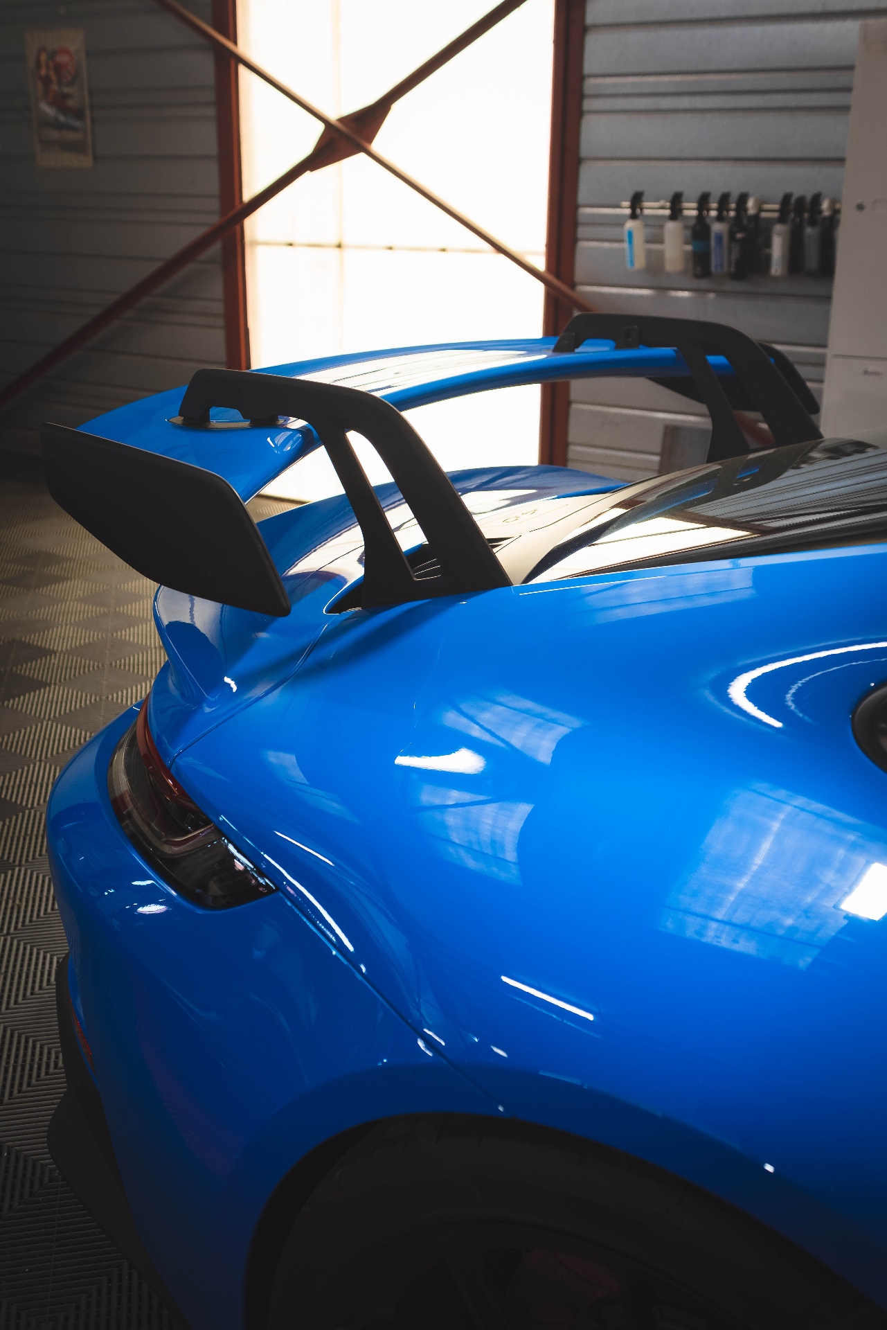 Aileron arrière de la Porsche 911 GT3 bleue dans la lumière de l'atelier