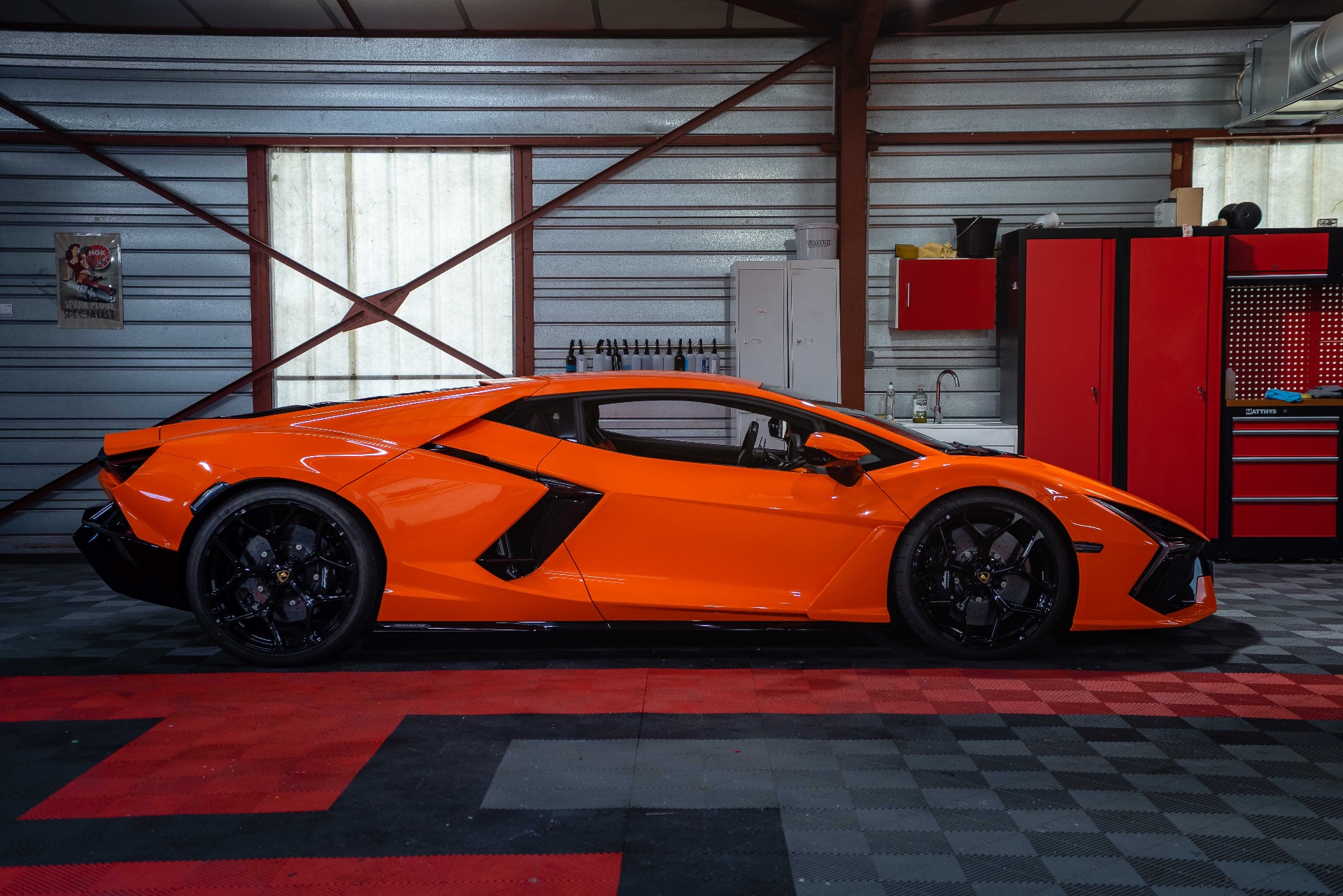 Lamborghini Revuelto orange, vue latérale dans l'atelier